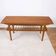 Scandinavian coffee table in teak with a lower shelf and brass bars.