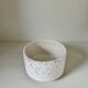 White ceramic vase with a textured effect.