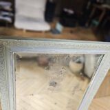 Old mirror with light green contours with mauve shades