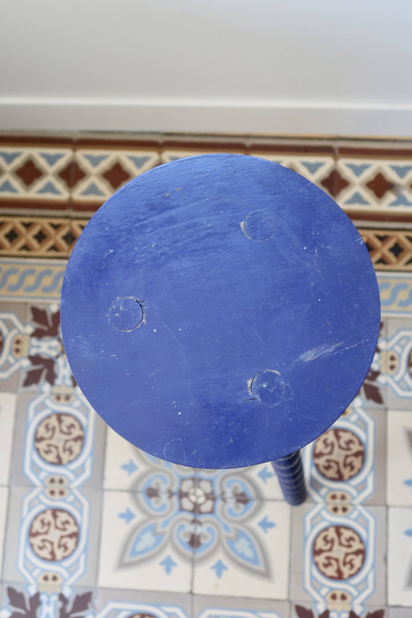 Vintage tripod stool made of turned wood, painted blue.