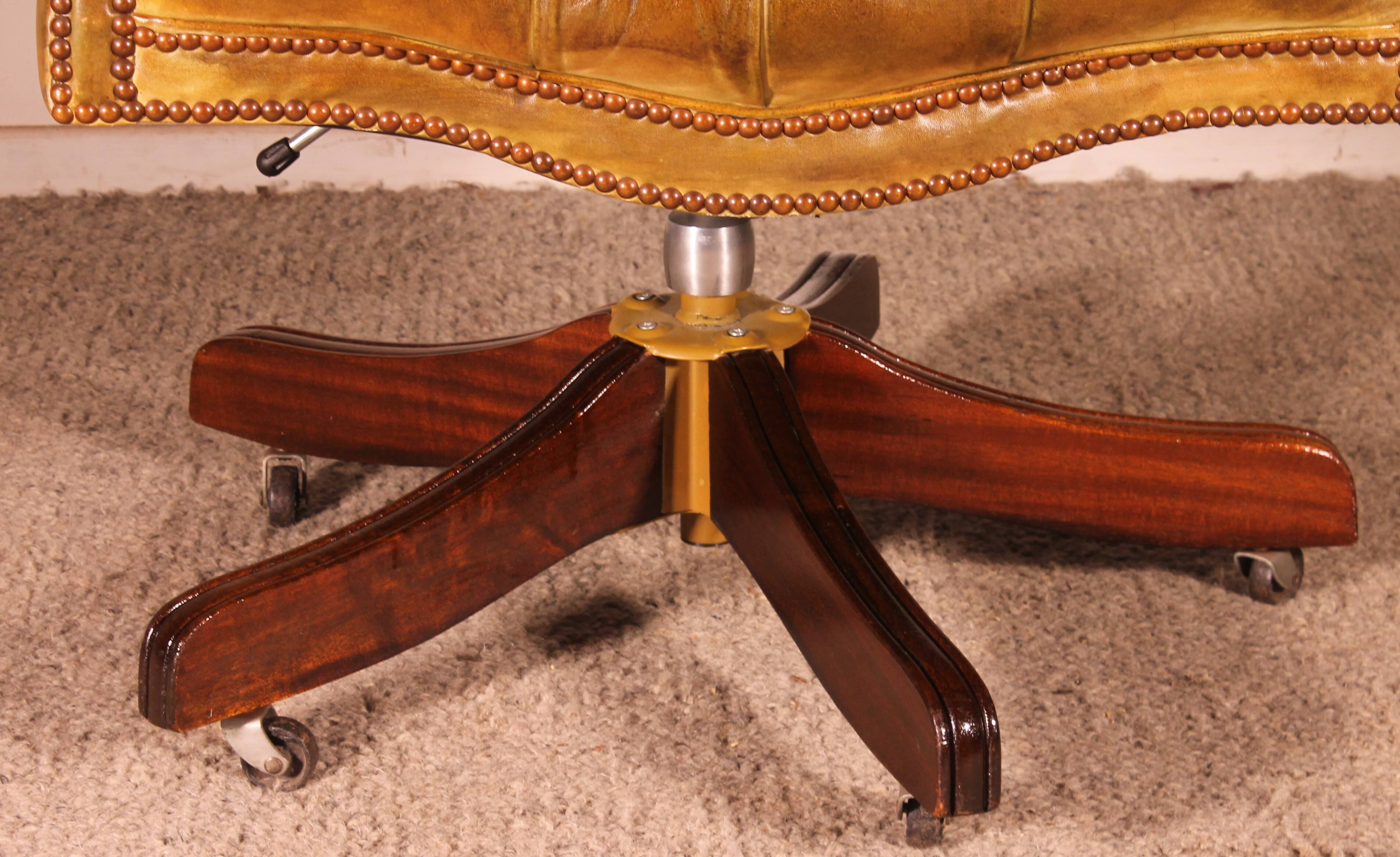 Office chair known as a presidential chair in mahogany and cognac leather.