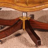 Office chair known as a presidential chair in mahogany and cognac leather.