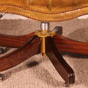 Office chair known as a presidential chair in mahogany and cognac leather.