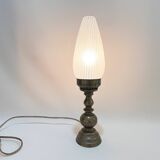 Old bronze or brass table lamp from the early 20th century with white streaked flame glass globe