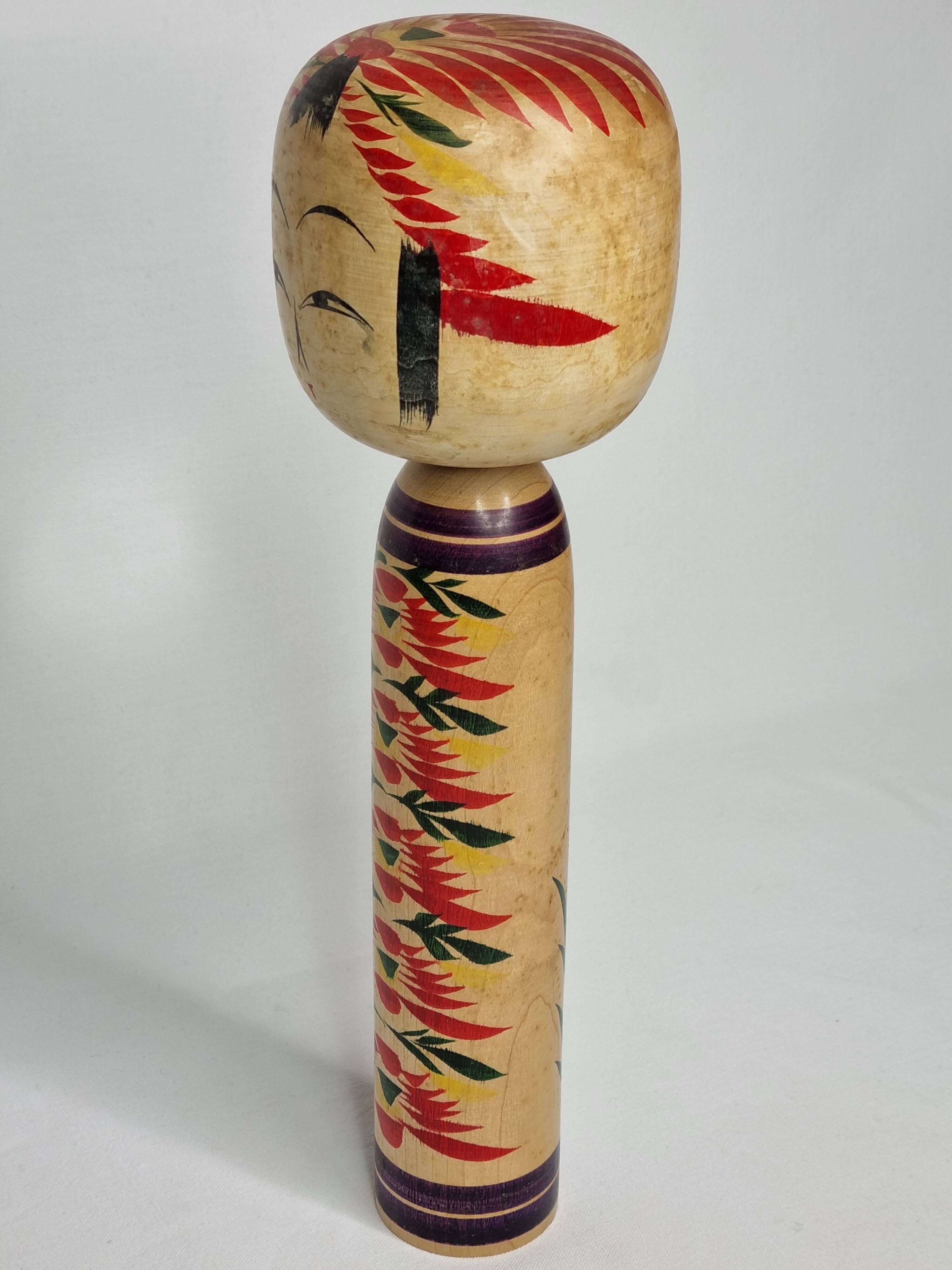 Japanese Kokeshi doll dated 1986, signed and numbered, hand-painted multi-colored floral decoration,
