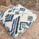 Berber floor pouf: Handwoven Moroccan wool cushion.
