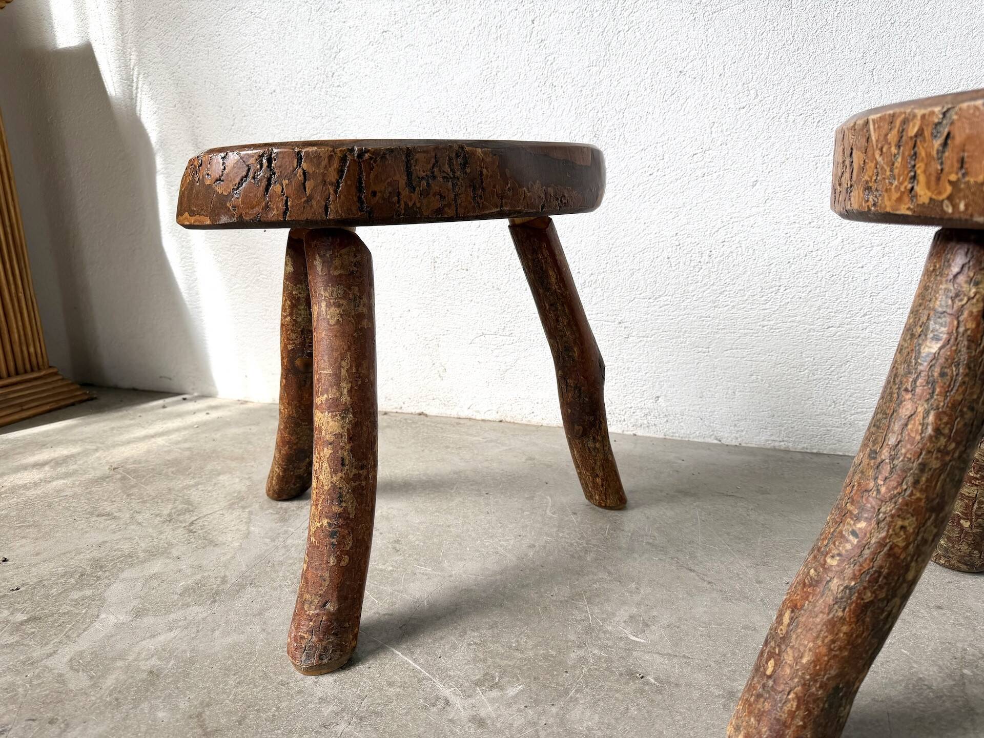 Set of three rustic solid wood tripod stools.