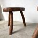 Set of three rustic solid wood tripod stools.