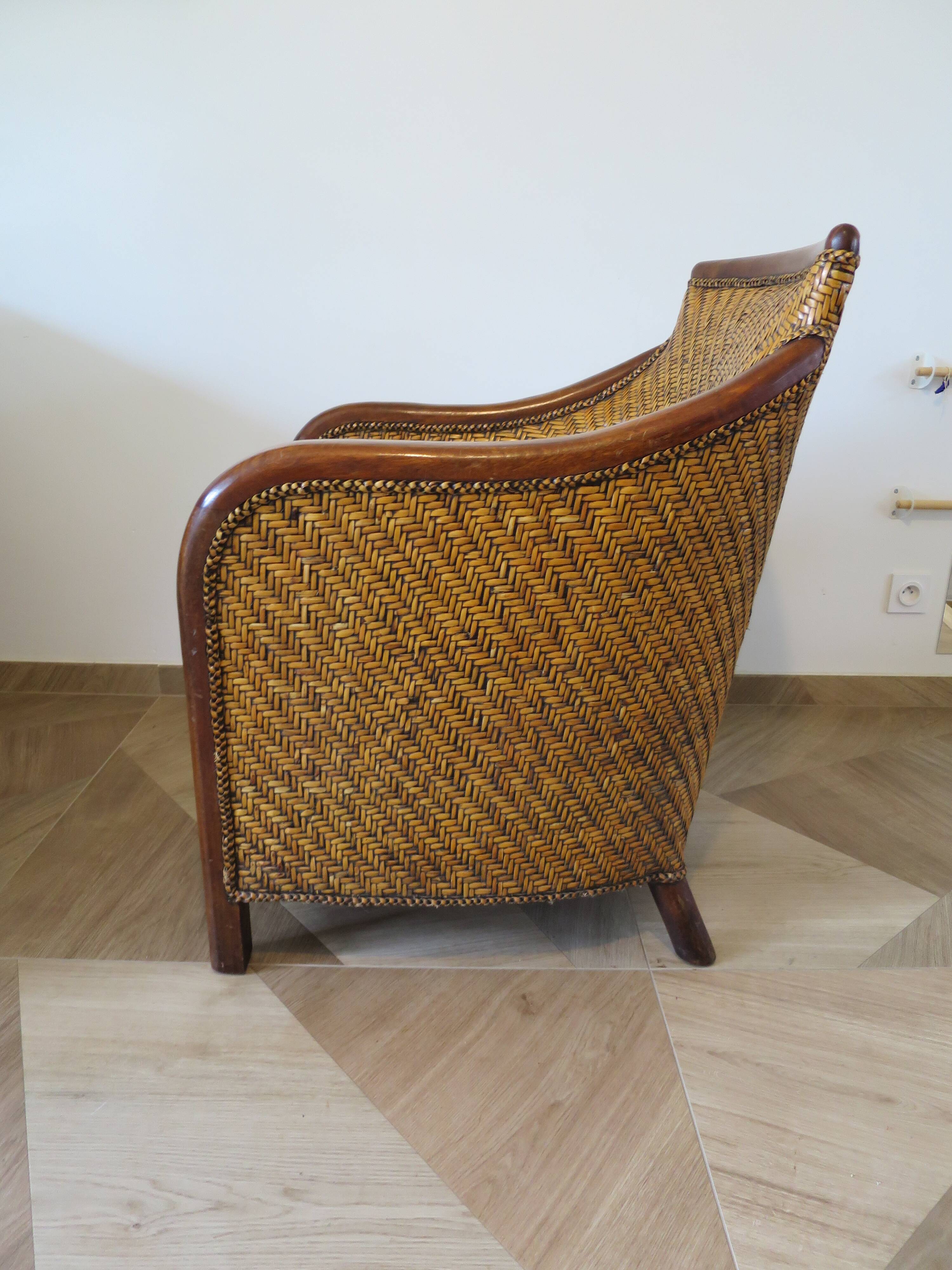 Colonial style armchair in woven rattan and exotic wood
