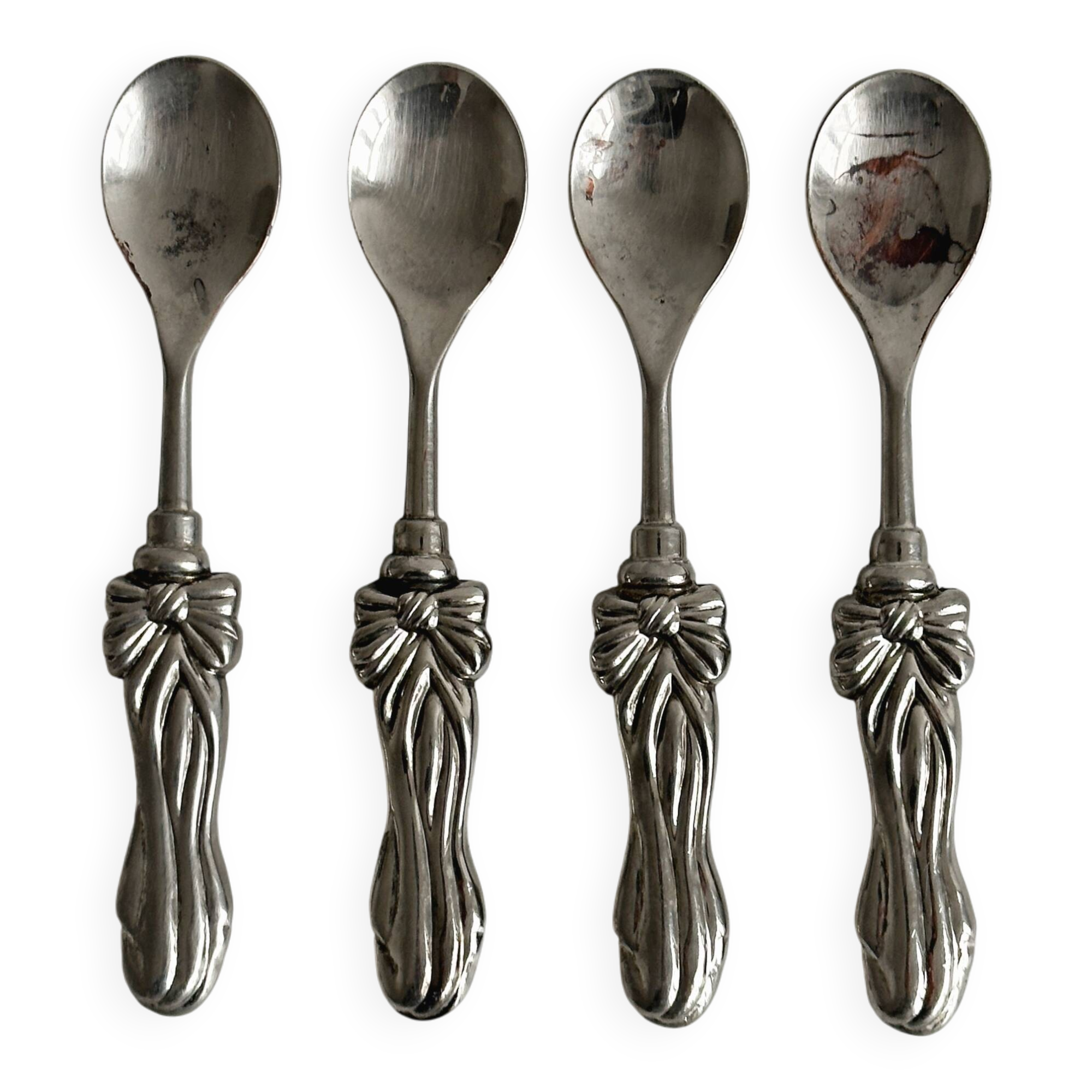 Antique small spoons with a metal bow design