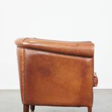 Cognac-colored cow leather club chair finished with decorative nails in English style