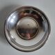 Shallow round metal plate with pearl bead decoration.