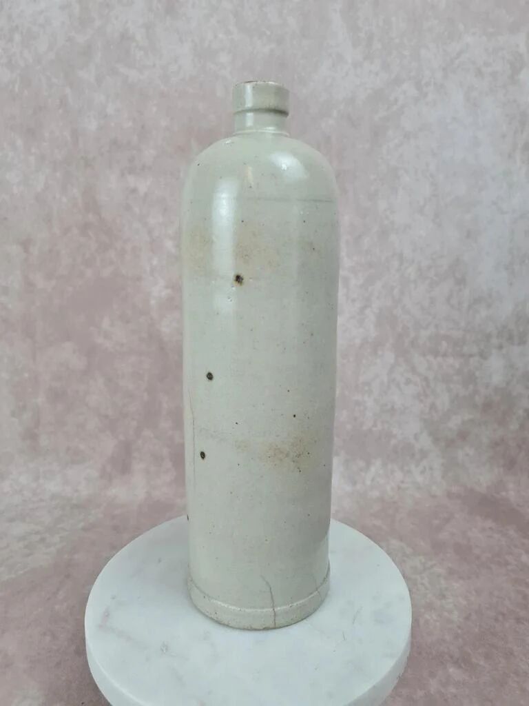 Antique beige glazed stoneware bottle from the 19th century, with a handle, vintage decor.