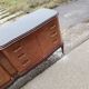 Mid-century Italian brown wooden chest of drawers, black glass top and brass handles.