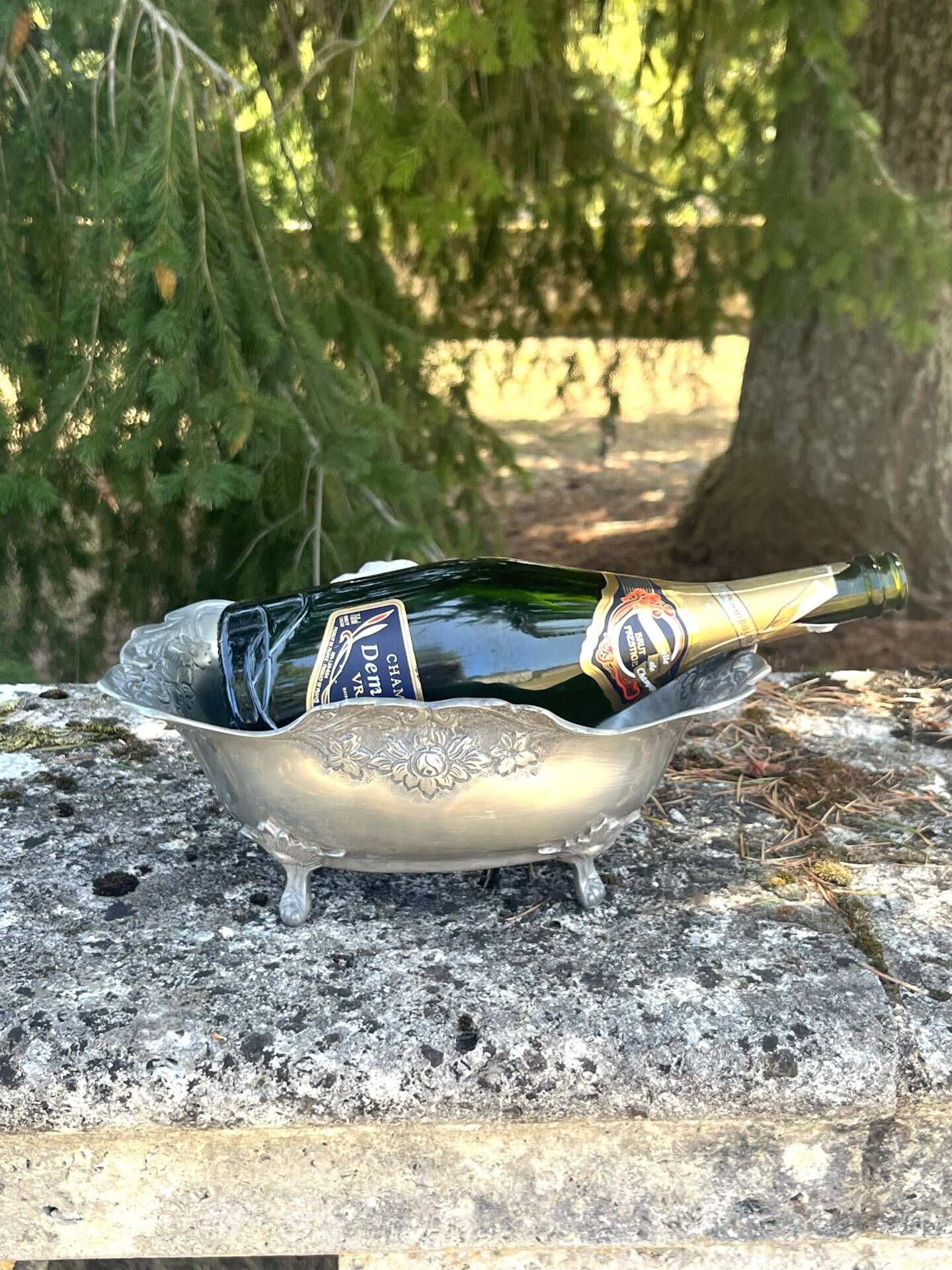 Footed pewter champagne cooler on claw feet with floral relief