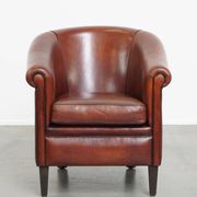 Sheepskin club armchair in a warm deep colour finished with black piping