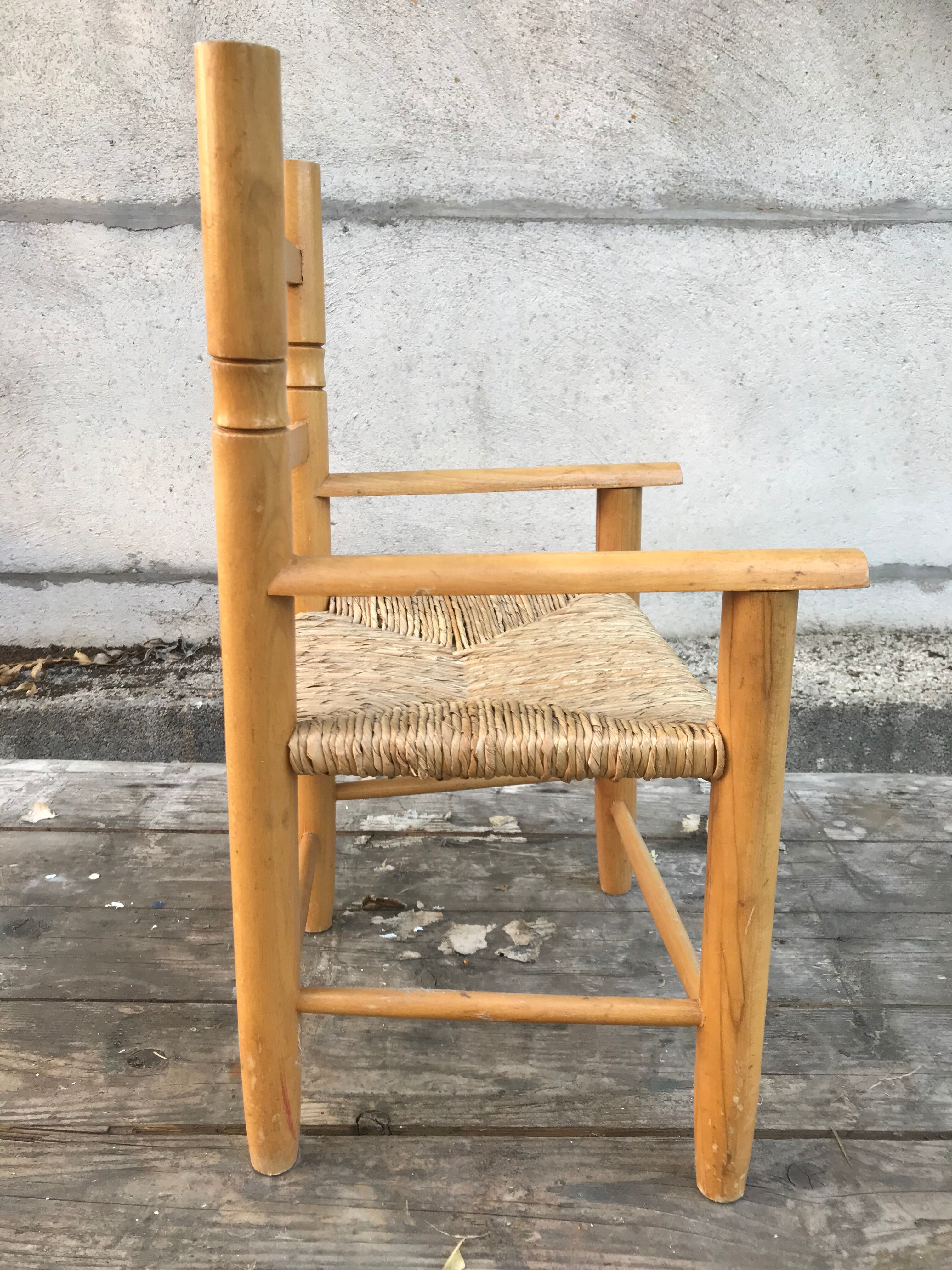 Old wooden children's armchair and vintage woven straw seat