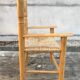 Old wooden children's armchair and vintage woven straw seat