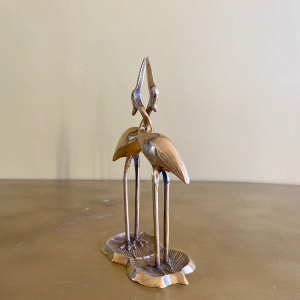 Couple of brass intertwined herons