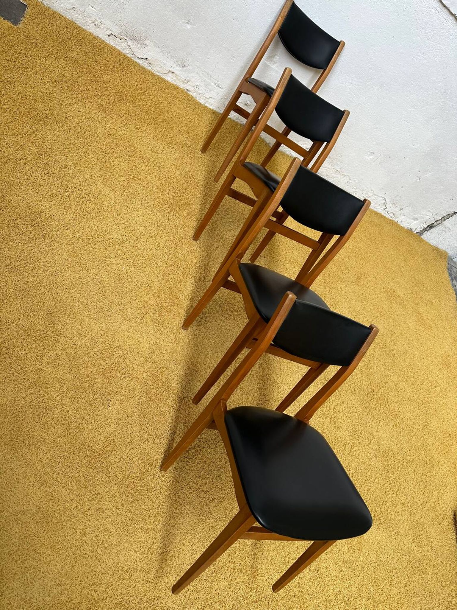 4 Scandinavian chairs in teak and black faux leather.