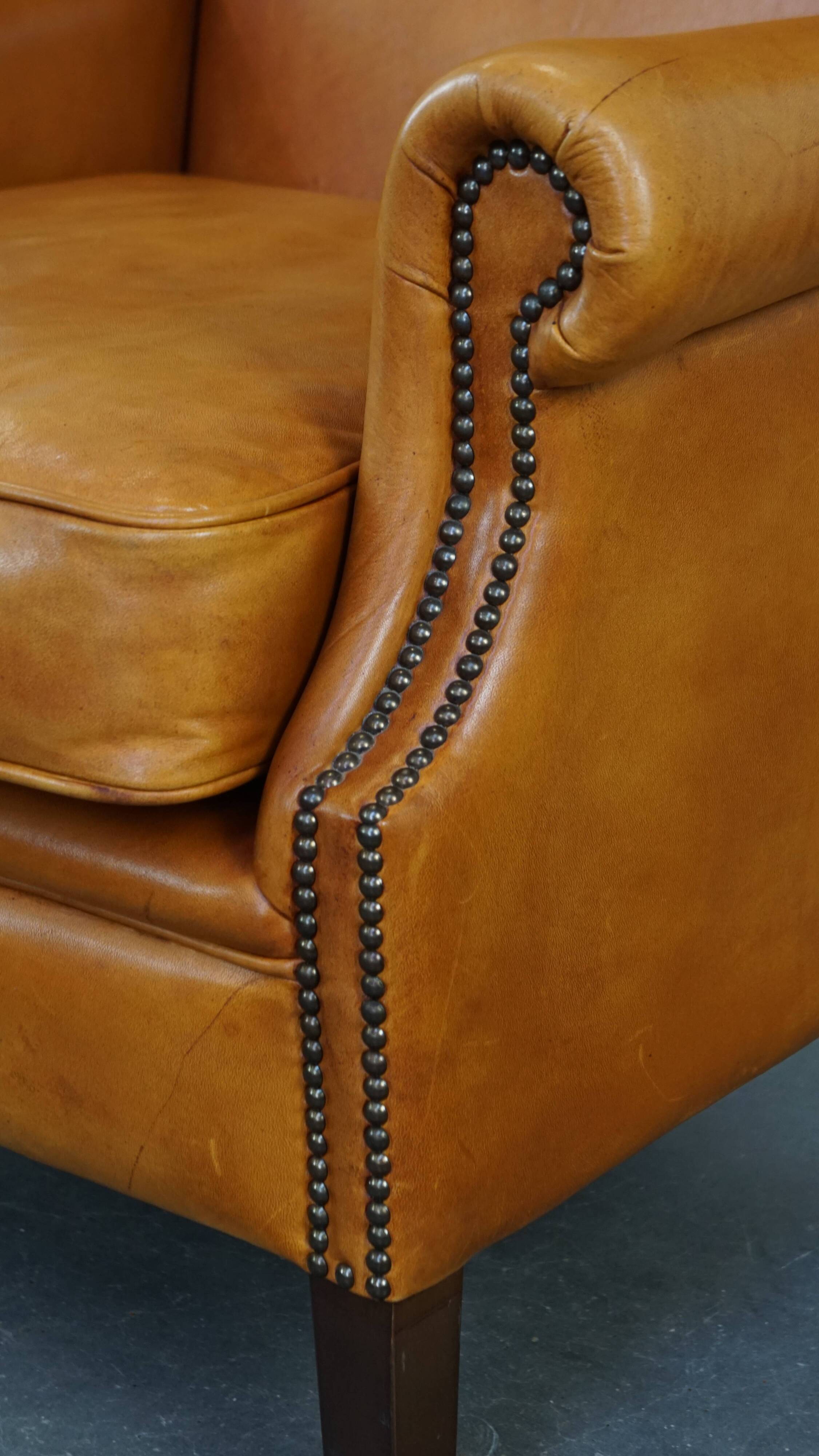 Cow leather wingback chair finished with decorative nails
