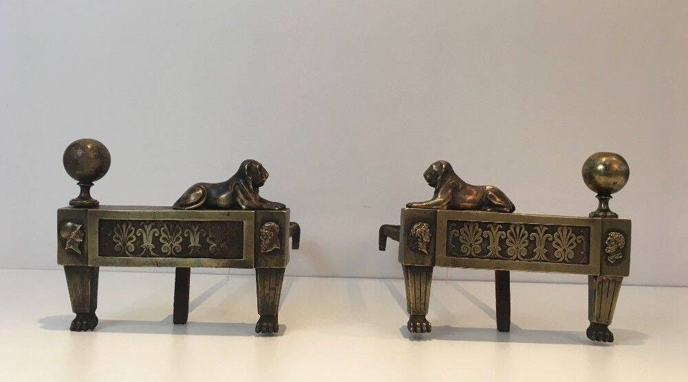 Paire de chenets d'époque Empire en bronze représentant des lions allongés