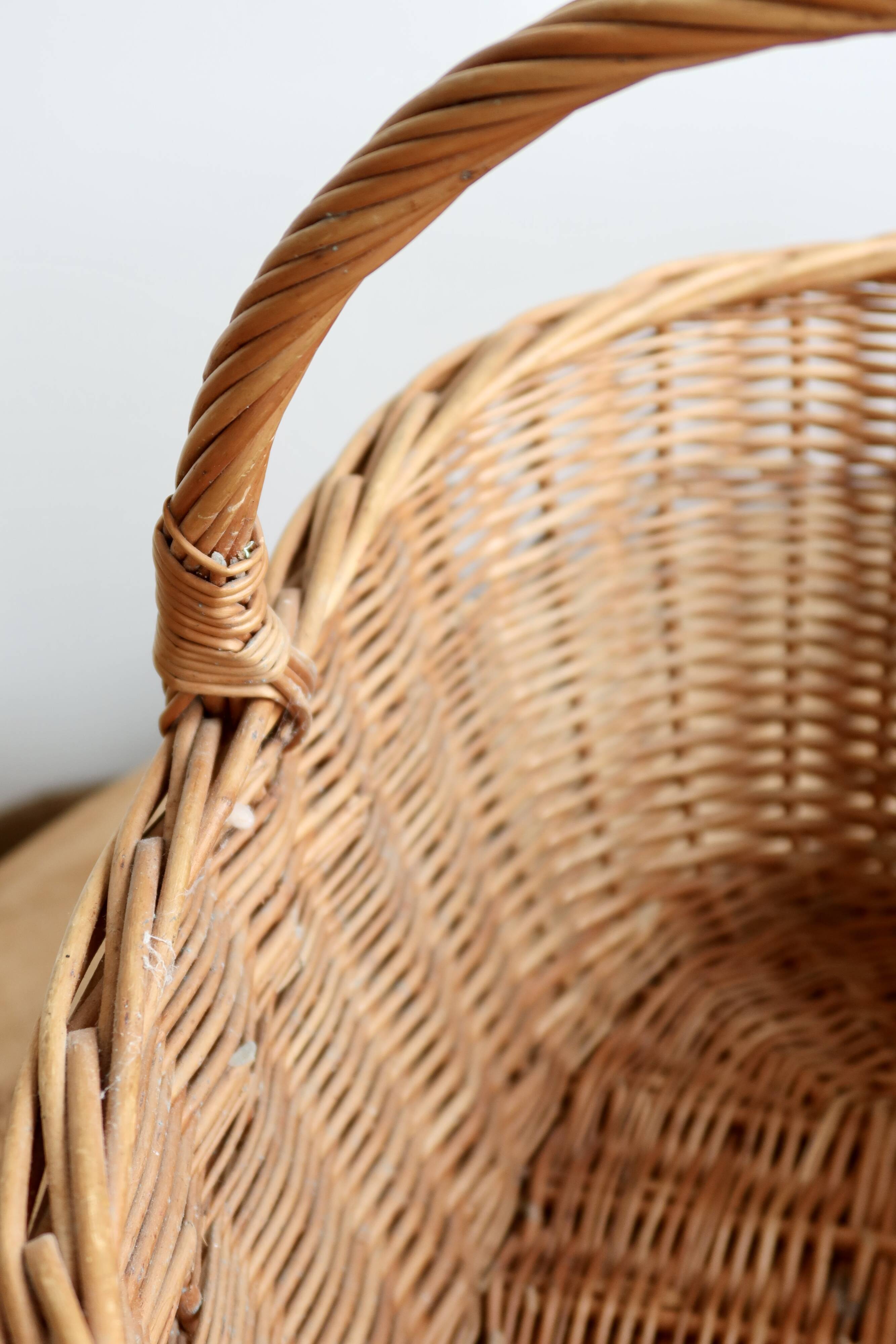 Large vintage woven wicker basket with a central handle.