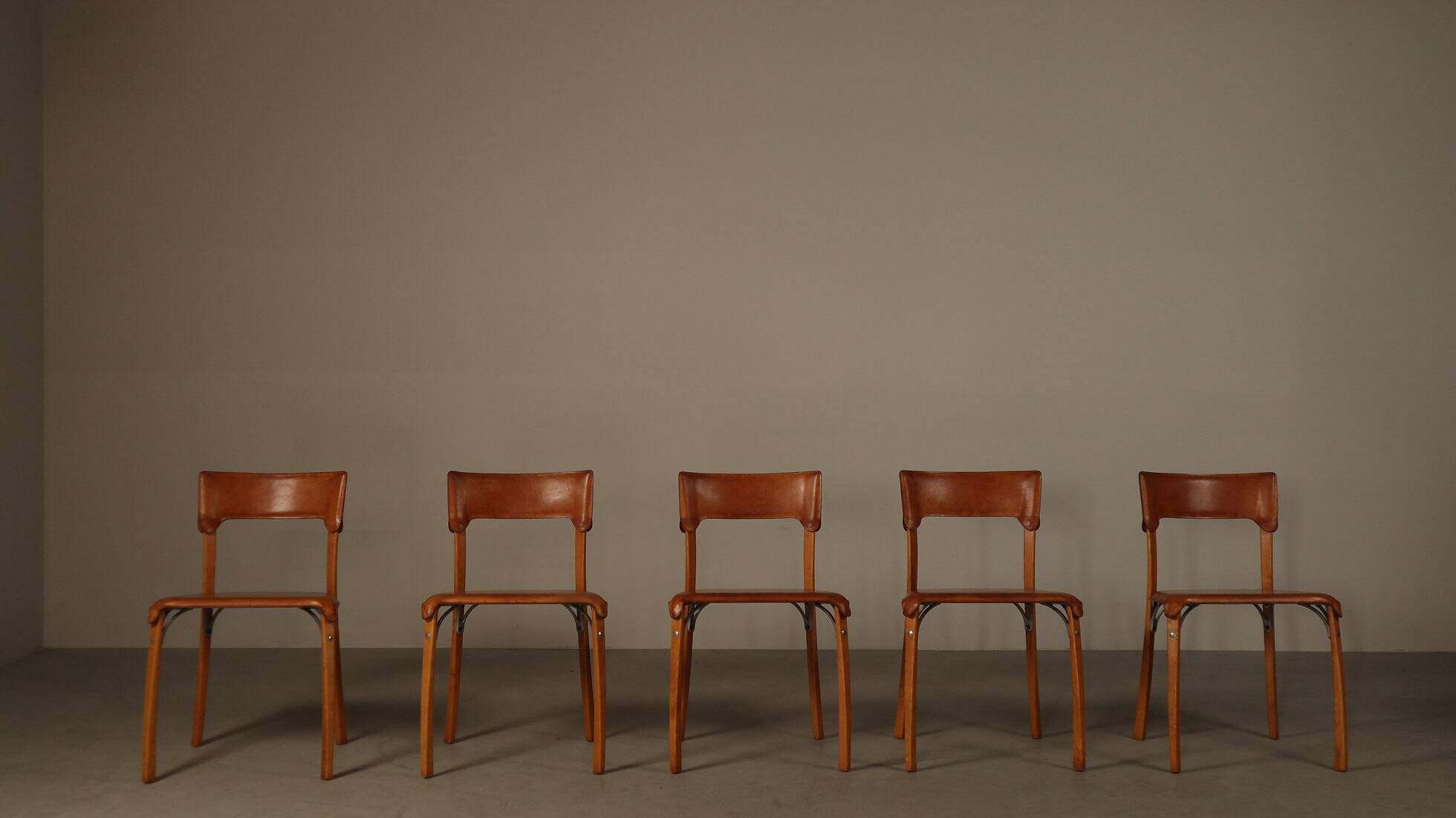 Ensemble de cinq chaises de salle à manger italiennes en cuir cognac, années 1990.