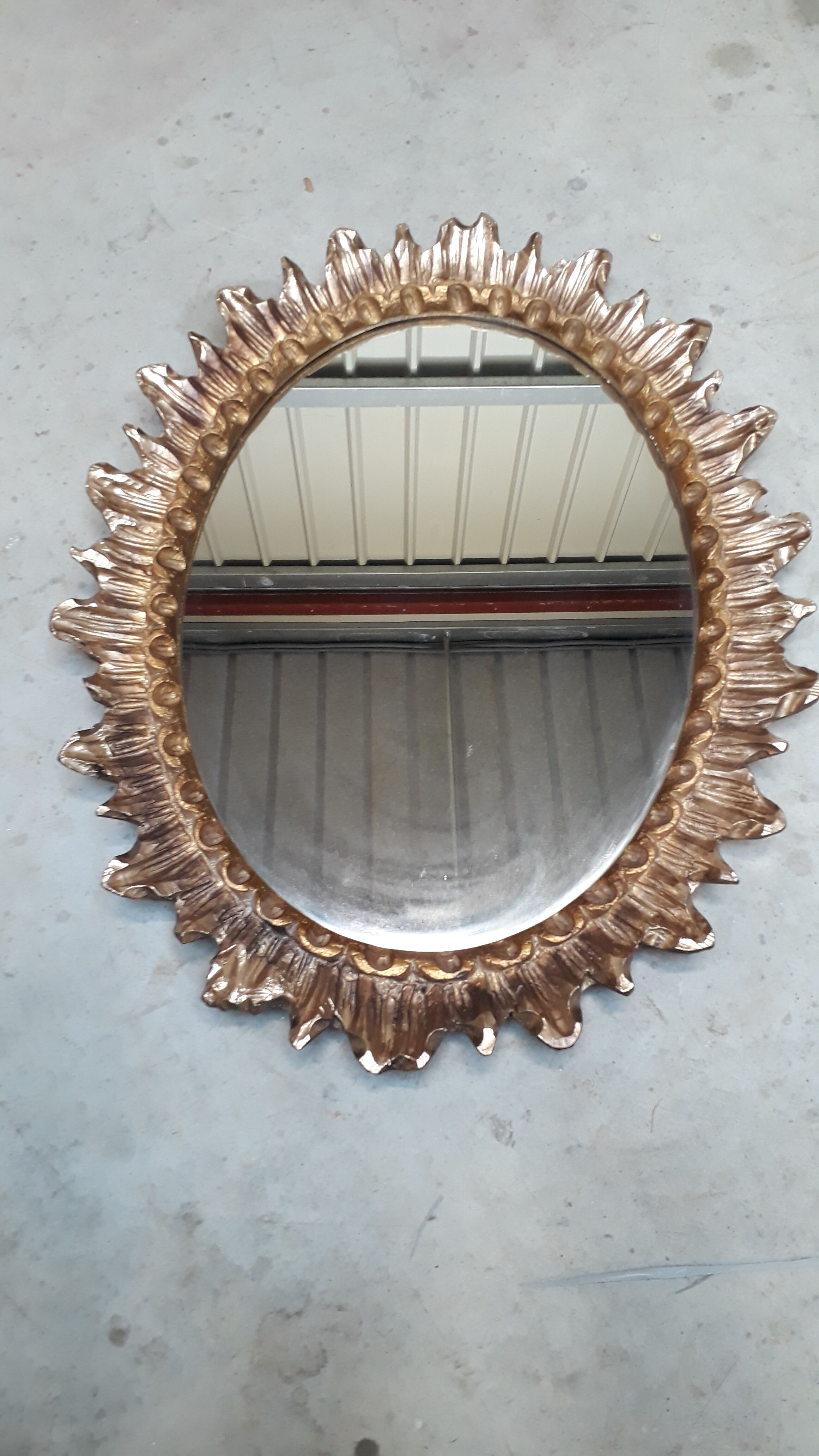 Oval sun mirror made of gilded solid wood
