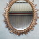 Oval sun mirror made of gilded solid wood