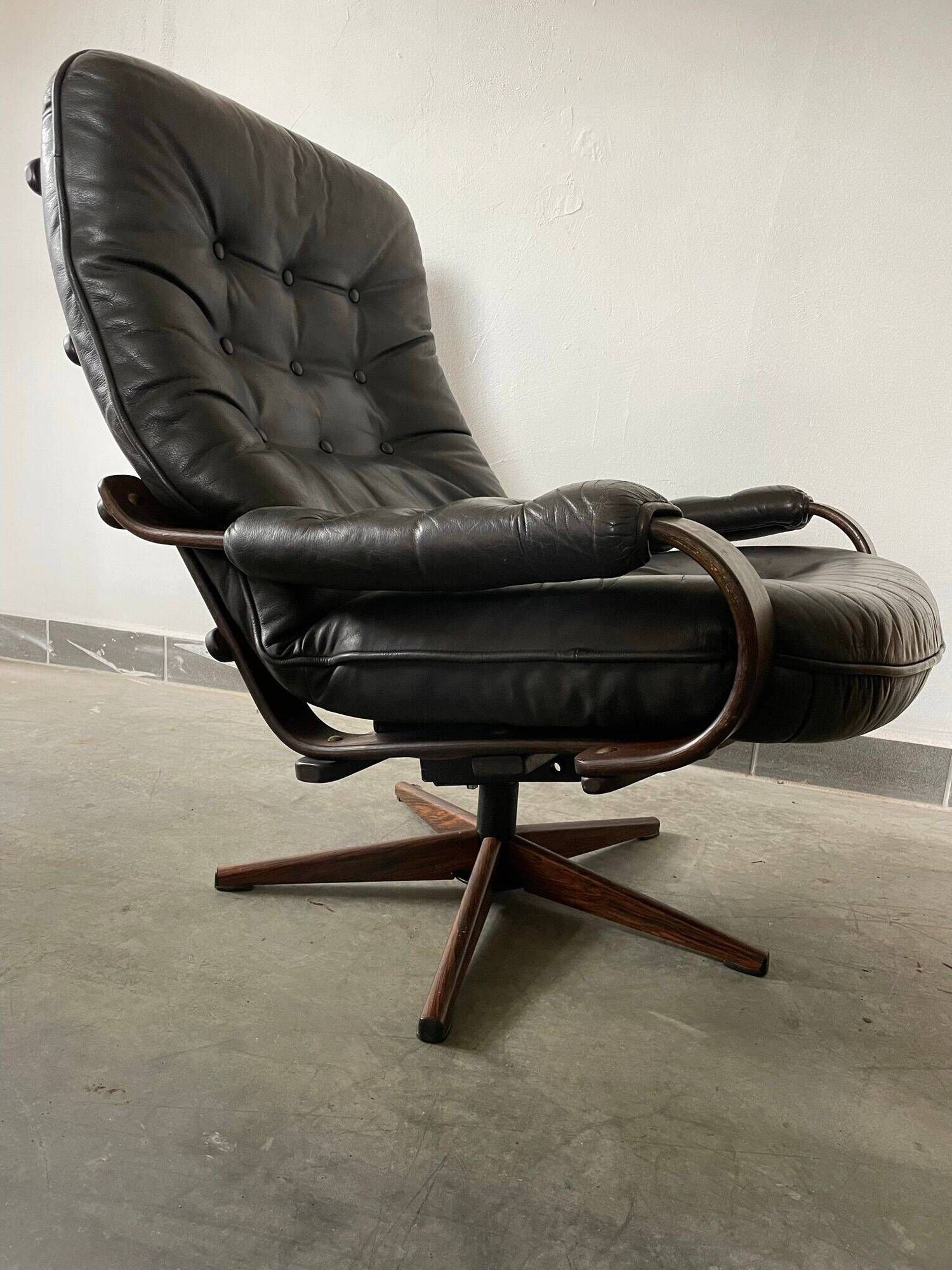 Scandinavian swivel lounge chair in black leather with a bent wood frame, 1970s.