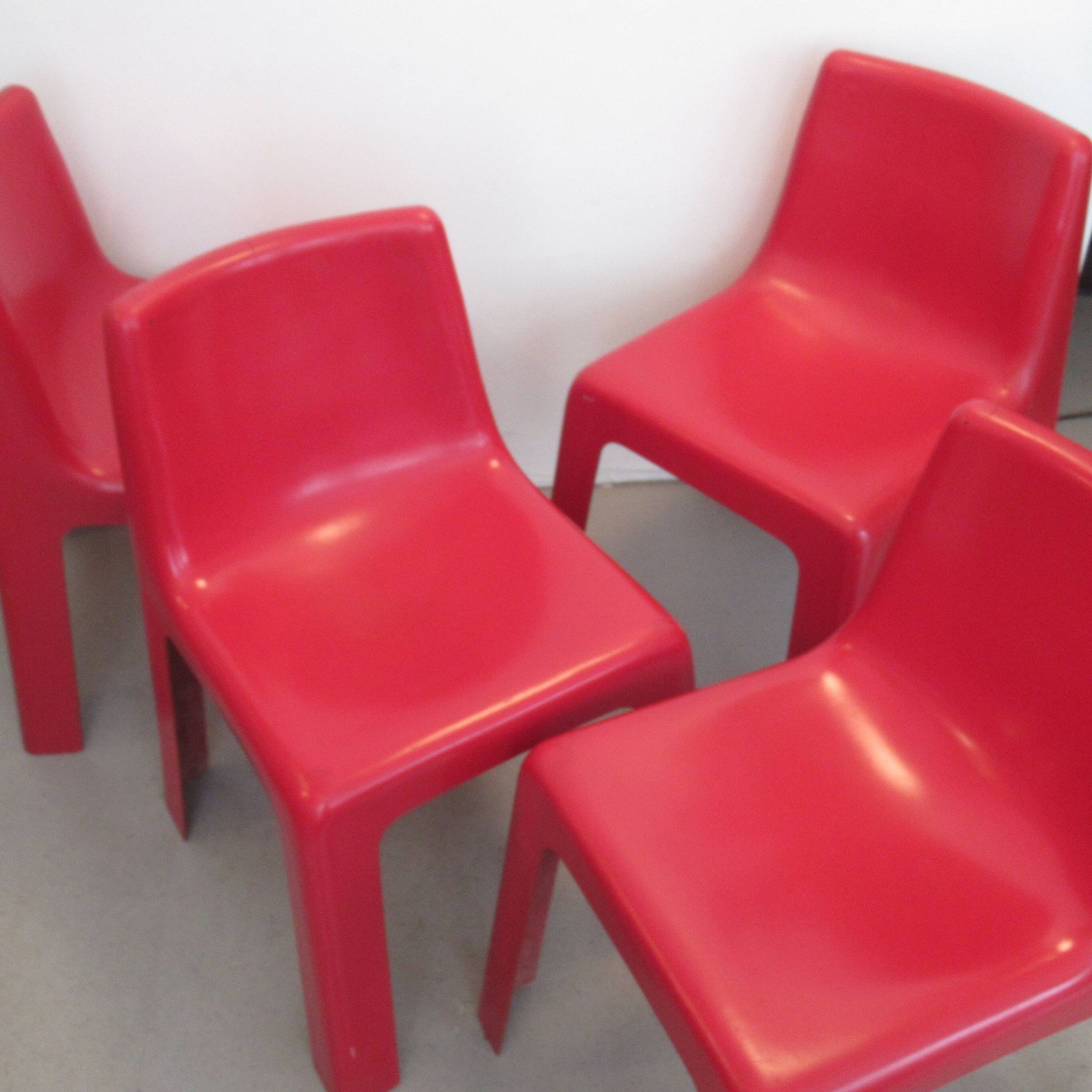 Four red fibreglass chairs from the 1970s.