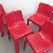 Four red fibreglass chairs from the 1970s.