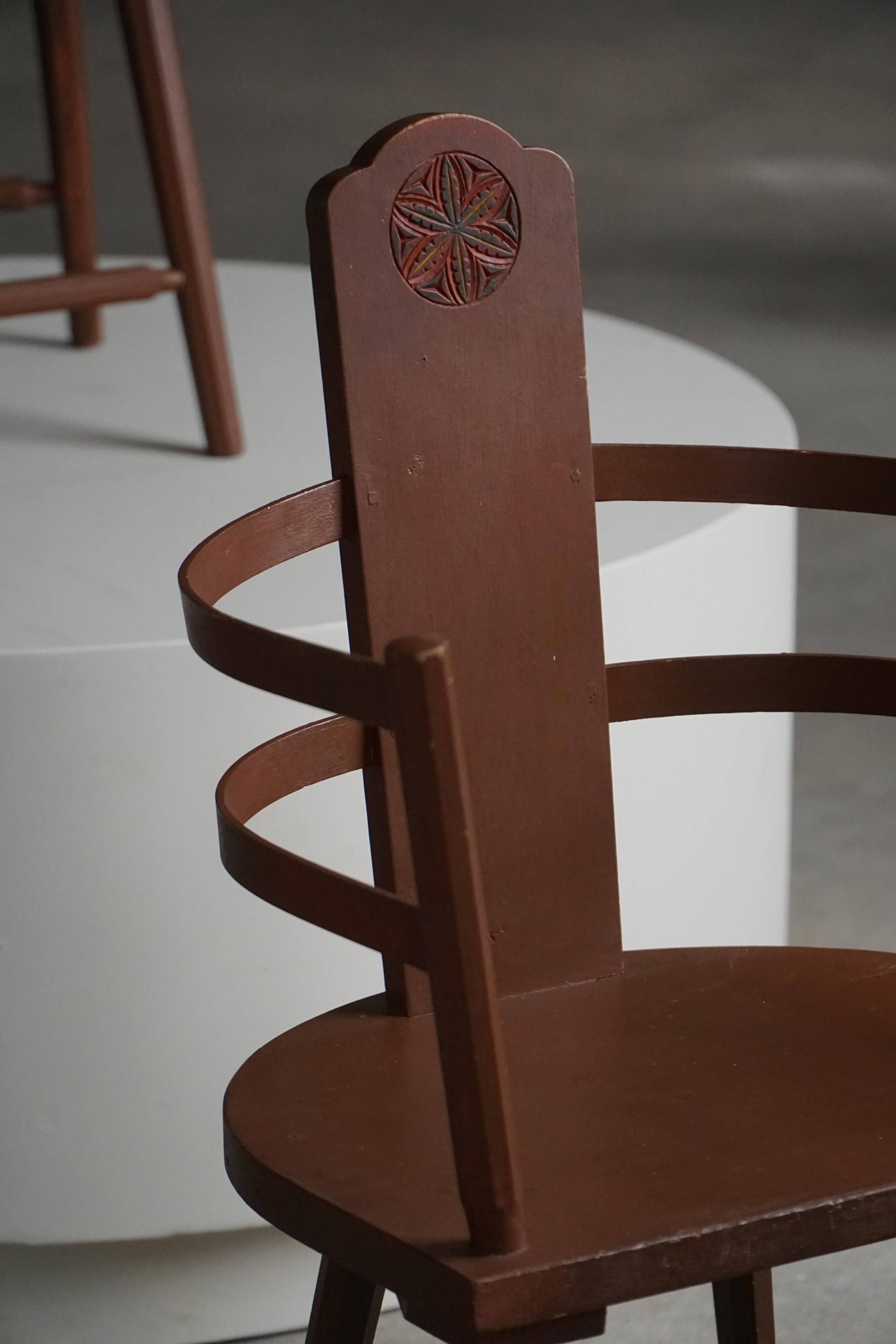 Pair of Scandinavian wooden armchairs with hand-carved folk motifs, 1920s.