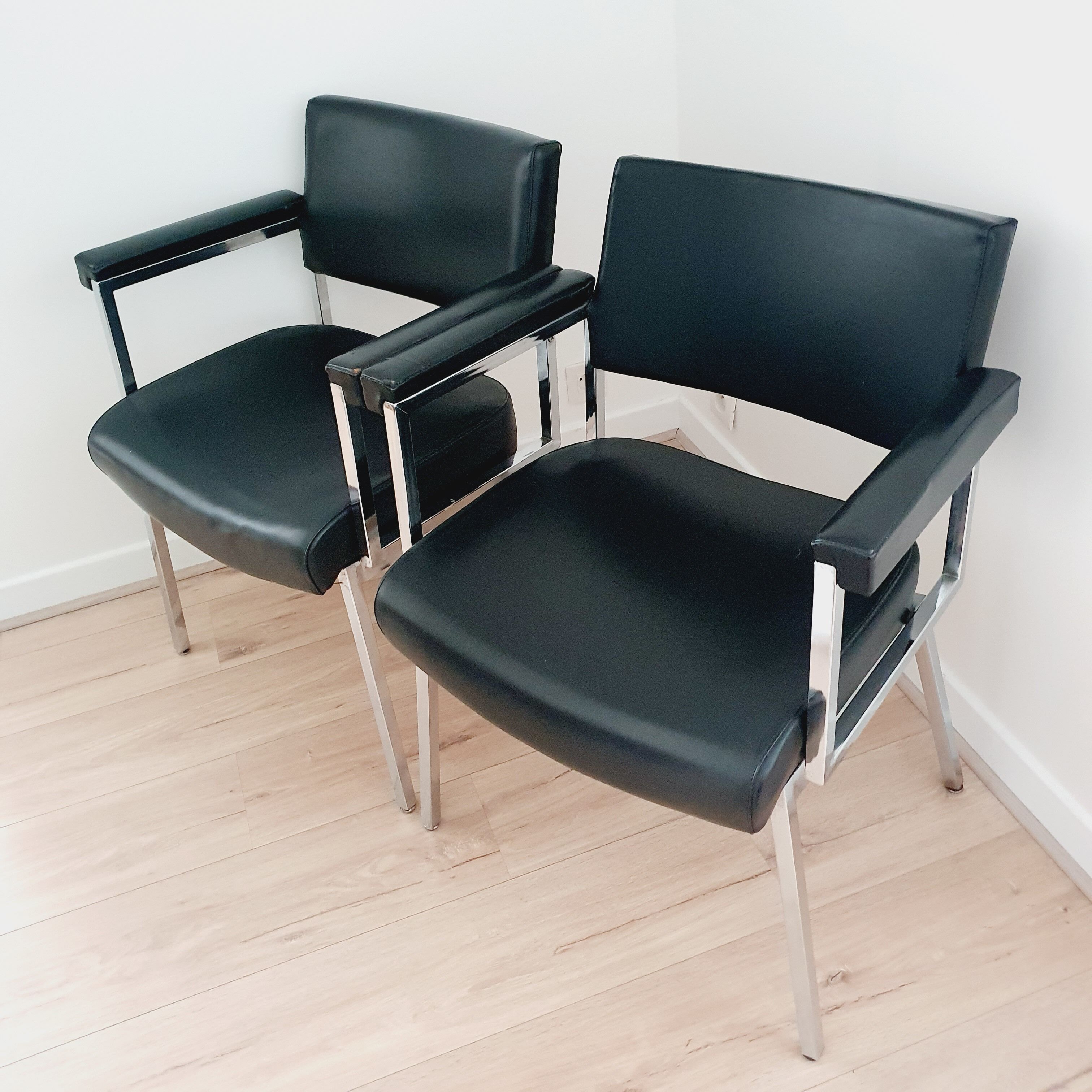 Pair of black skaï and chrome armchairs