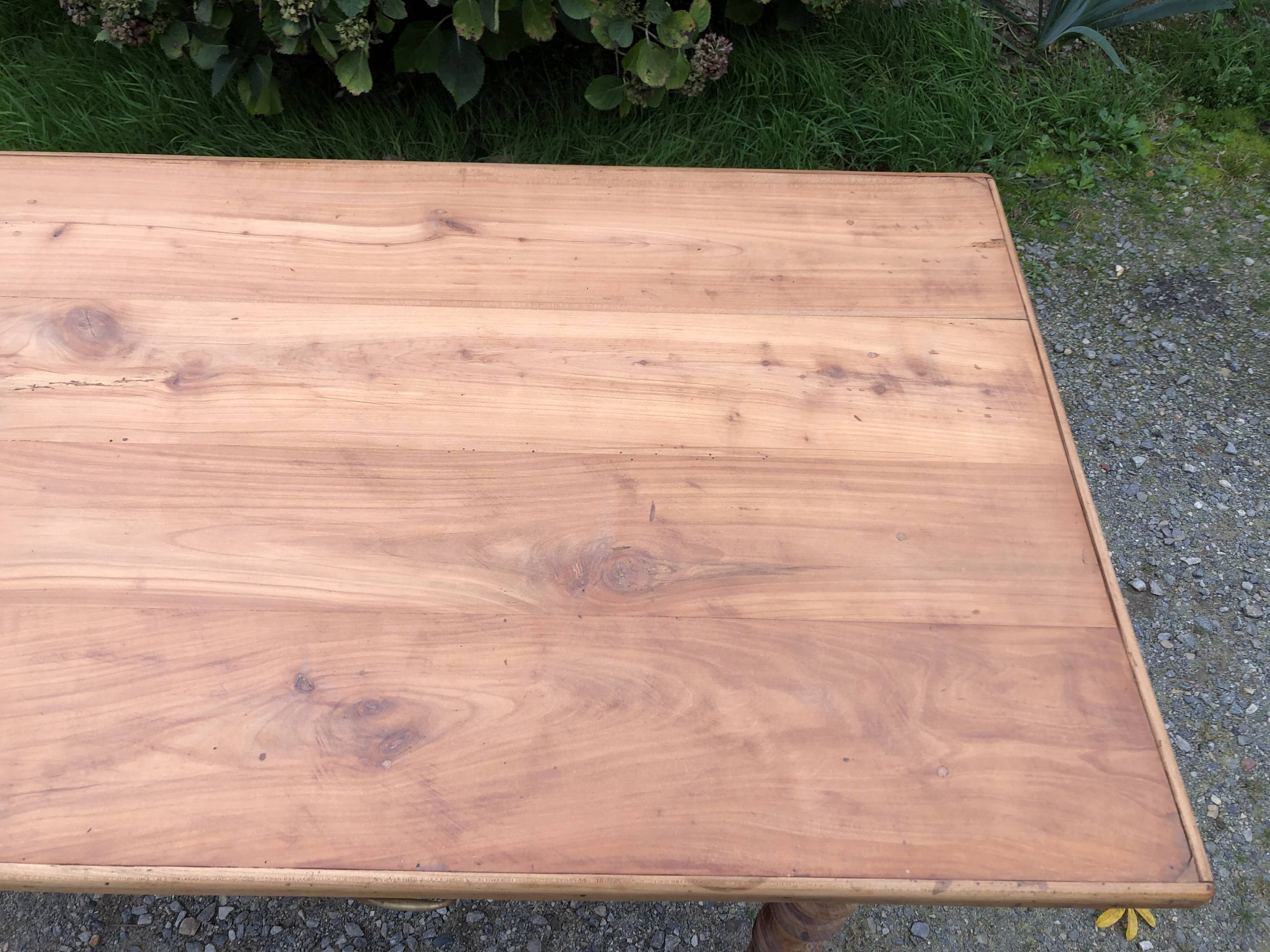 Antique Louis Philippe style farm table in solid cherry wood with 2 drawers and turned base.