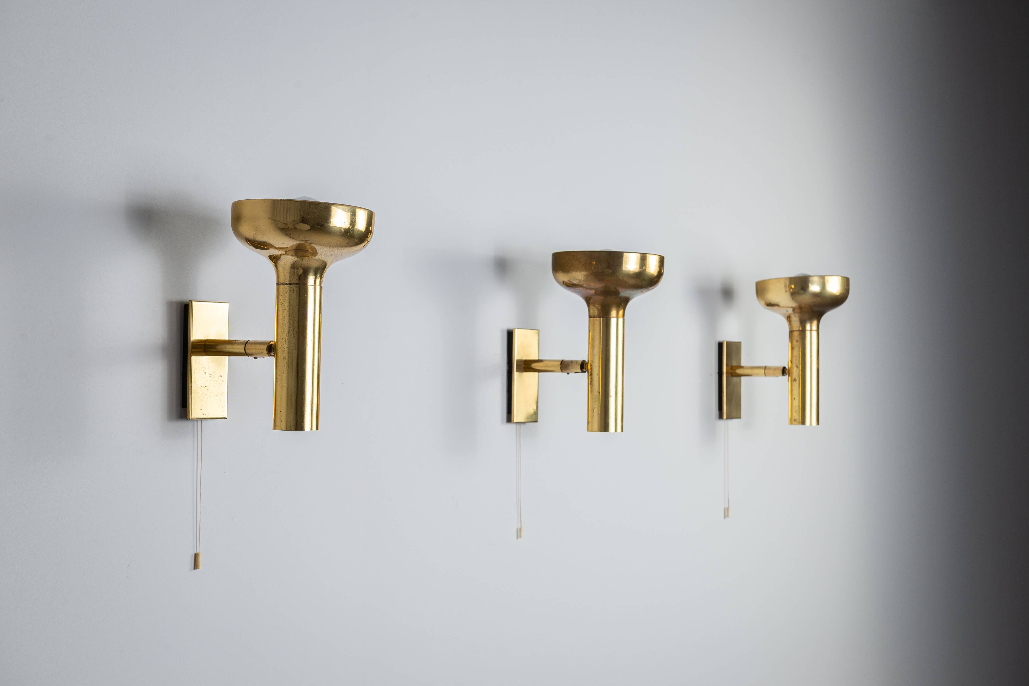 Set of three brass adjustable wall lamps