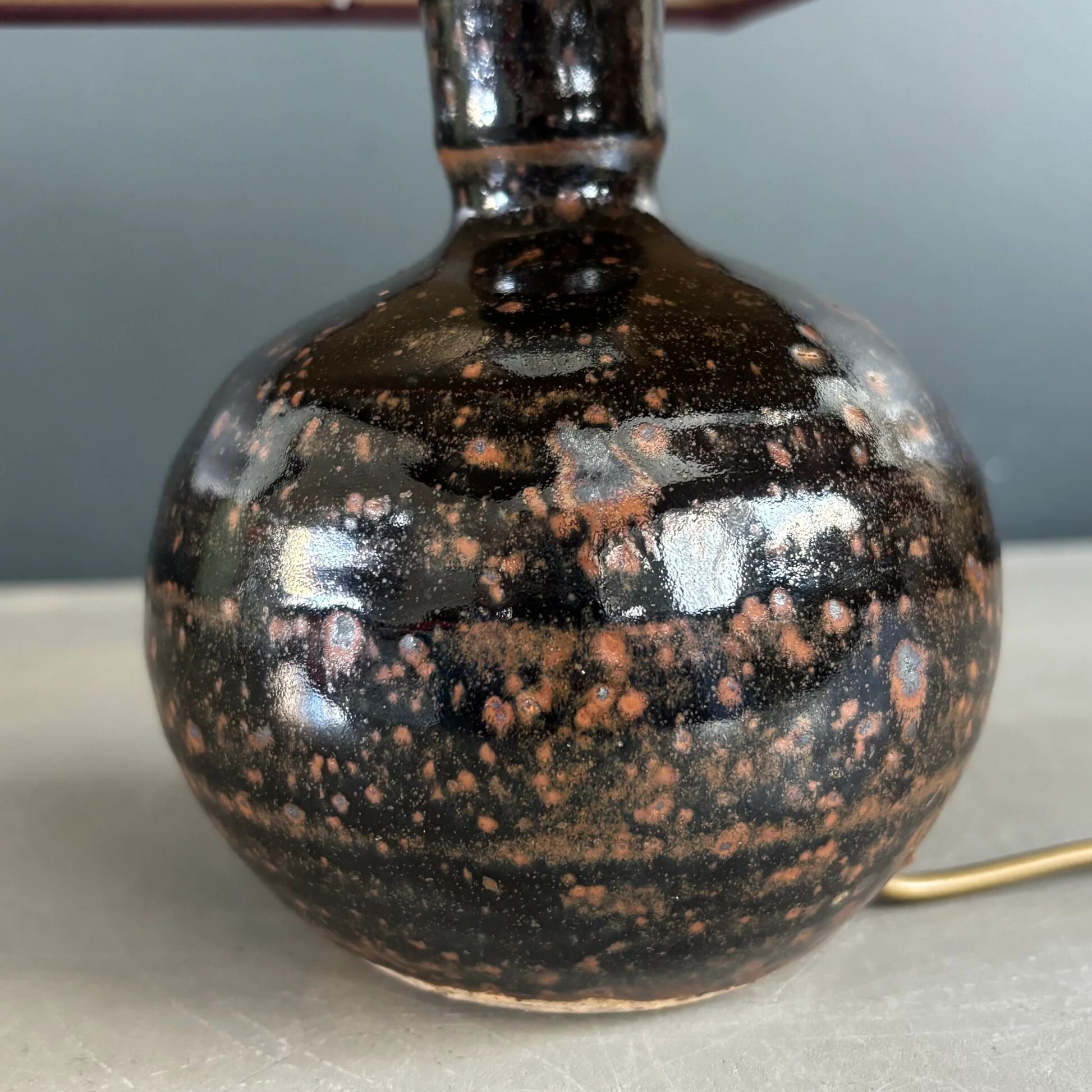 Ceramic floor lamp with a pyramidal shade and square base.