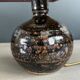 Ceramic floor lamp with a pyramidal shade and square base.