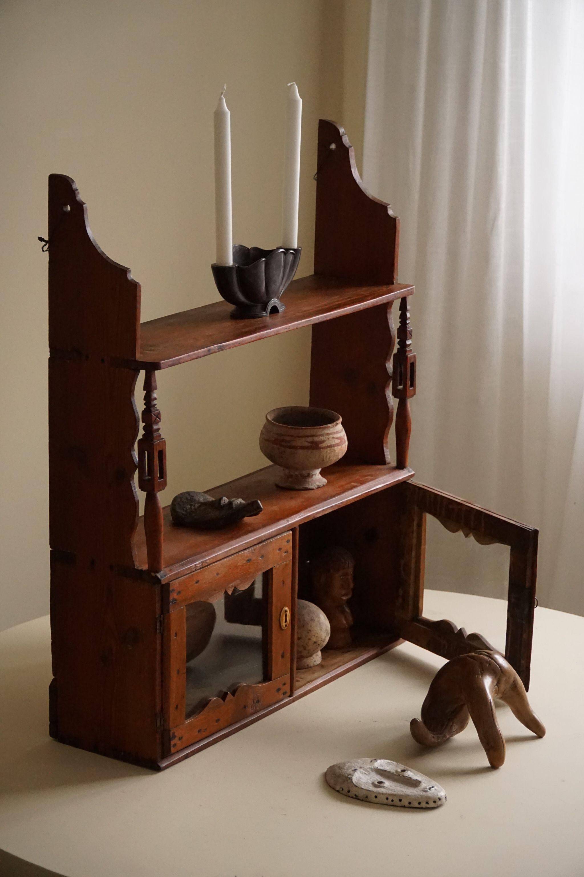Primitive wall shelf in pine, by a Swedish upholsterer, late 19th century.