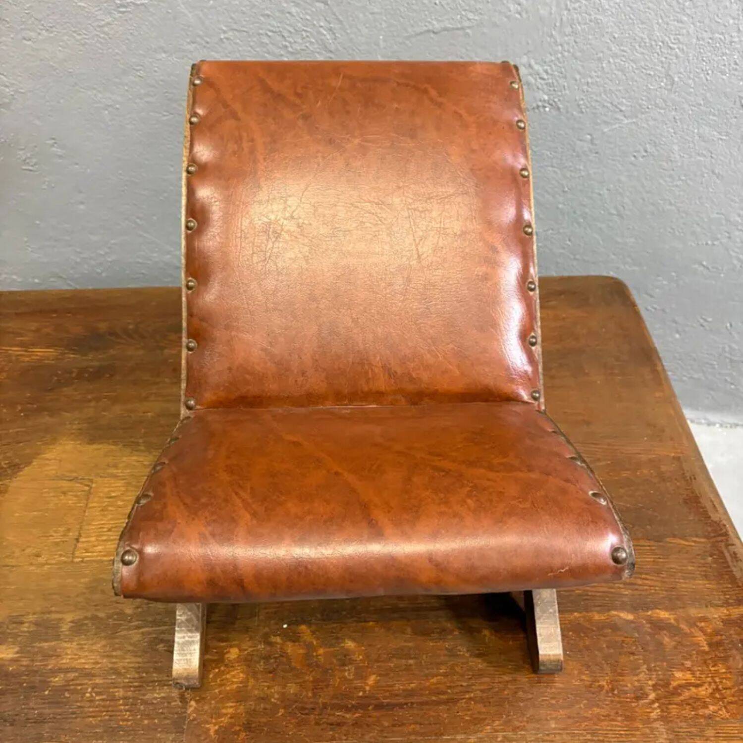 Old retro footstool, mid-century wooden leather stool, mid 20th century, European