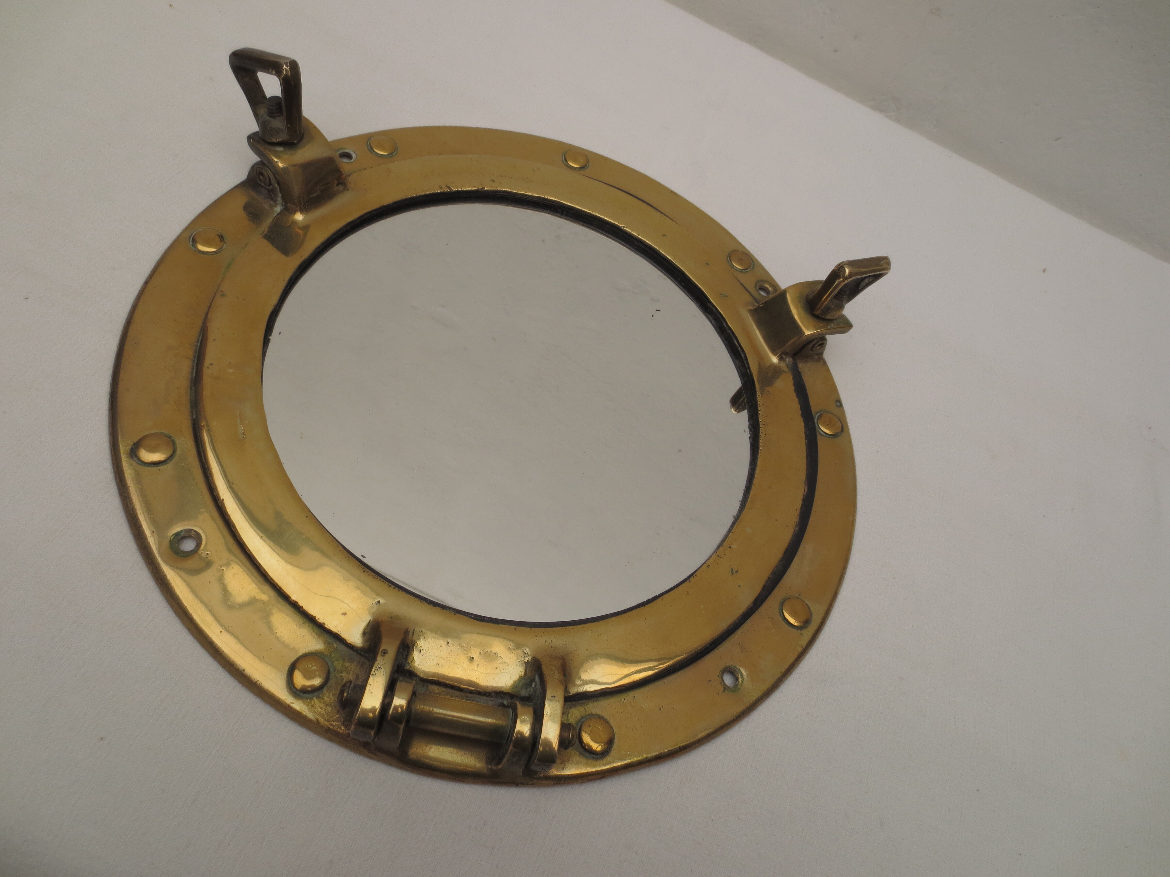 Mirror integrated into a brass navy porthole