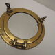 Mirror integrated into a brass navy porthole