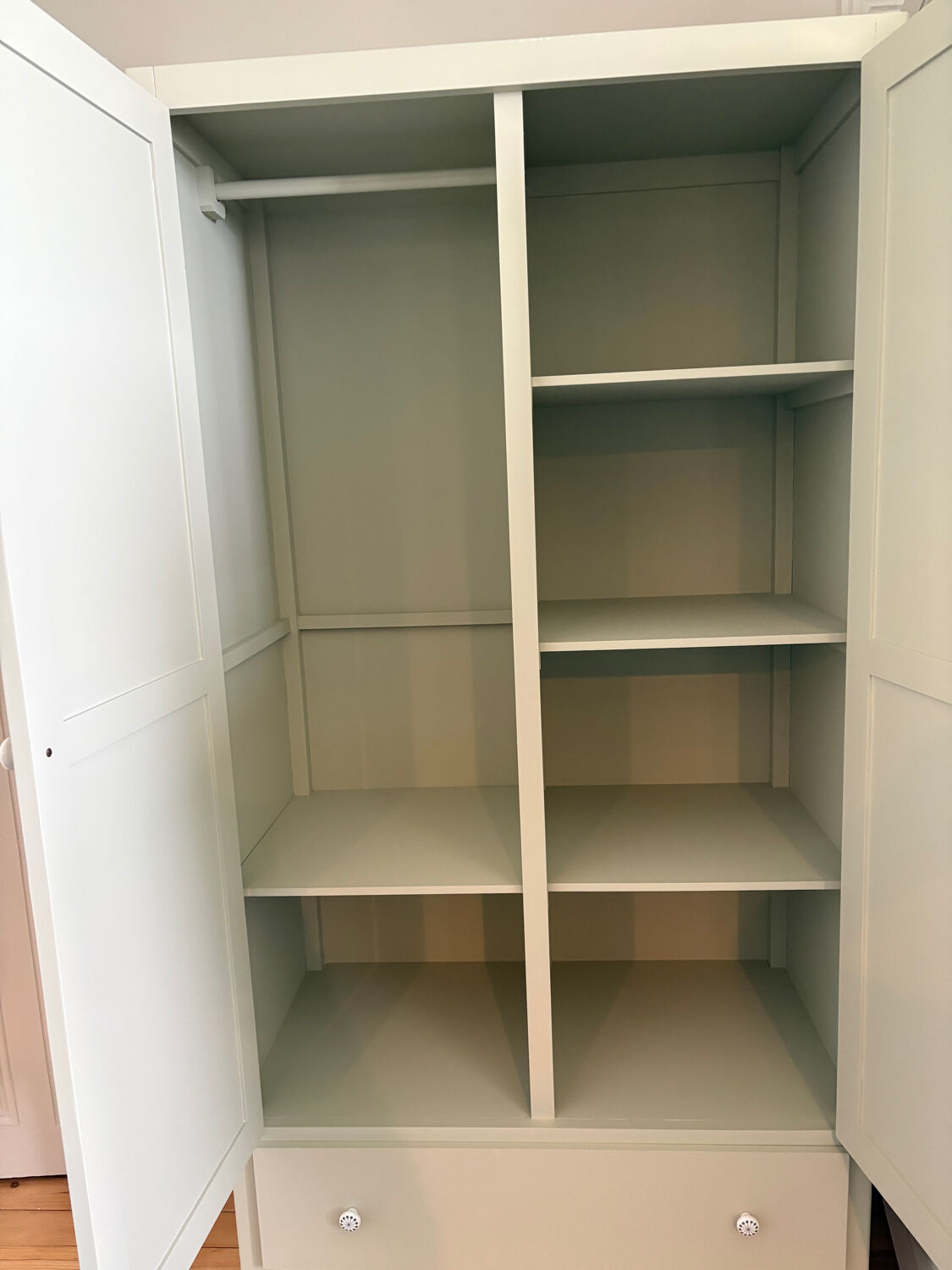 Mint green wardrobe with shelves and hanging space.