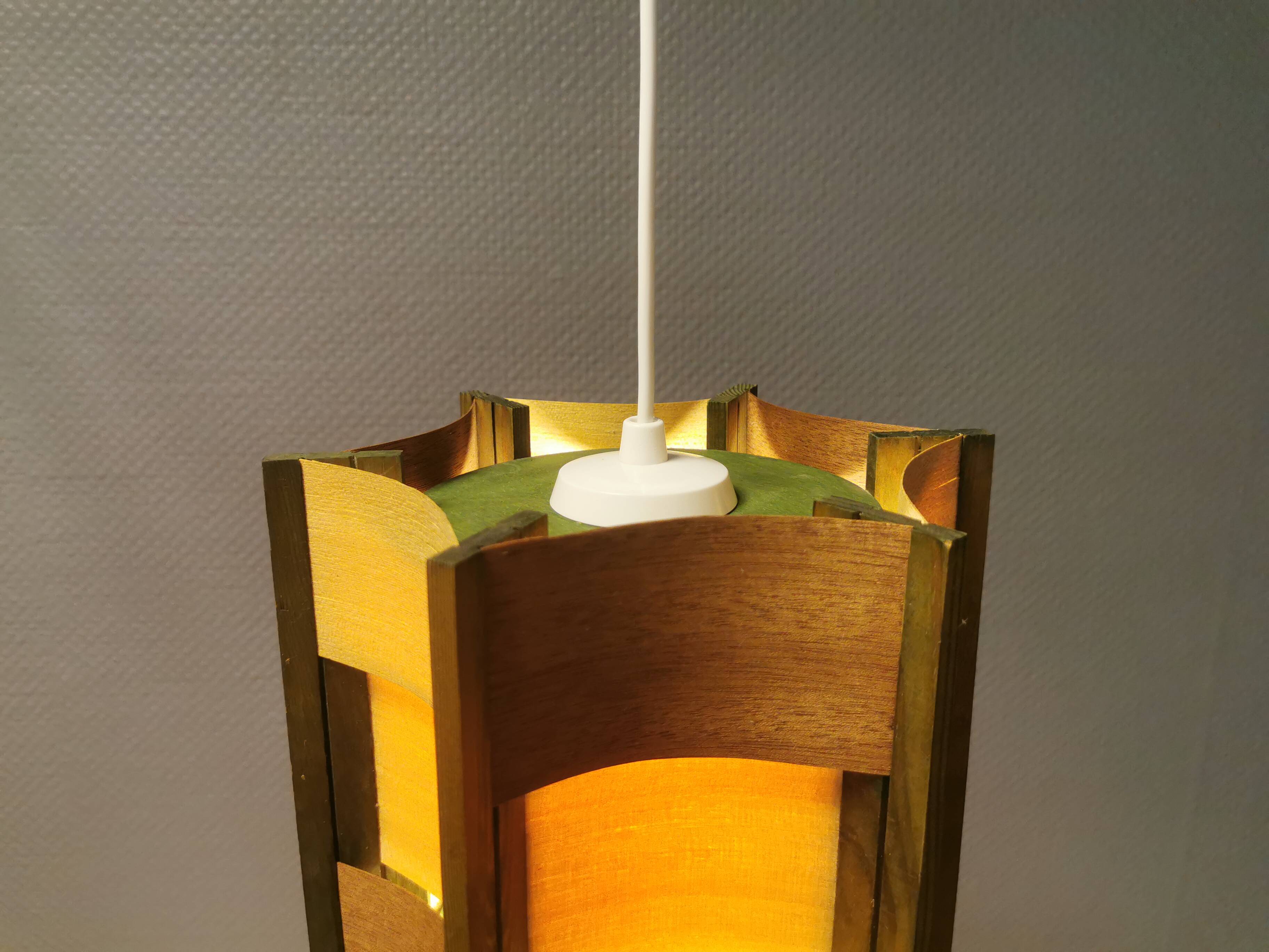 Older lamp in wood veneer, partially painted in green colour.