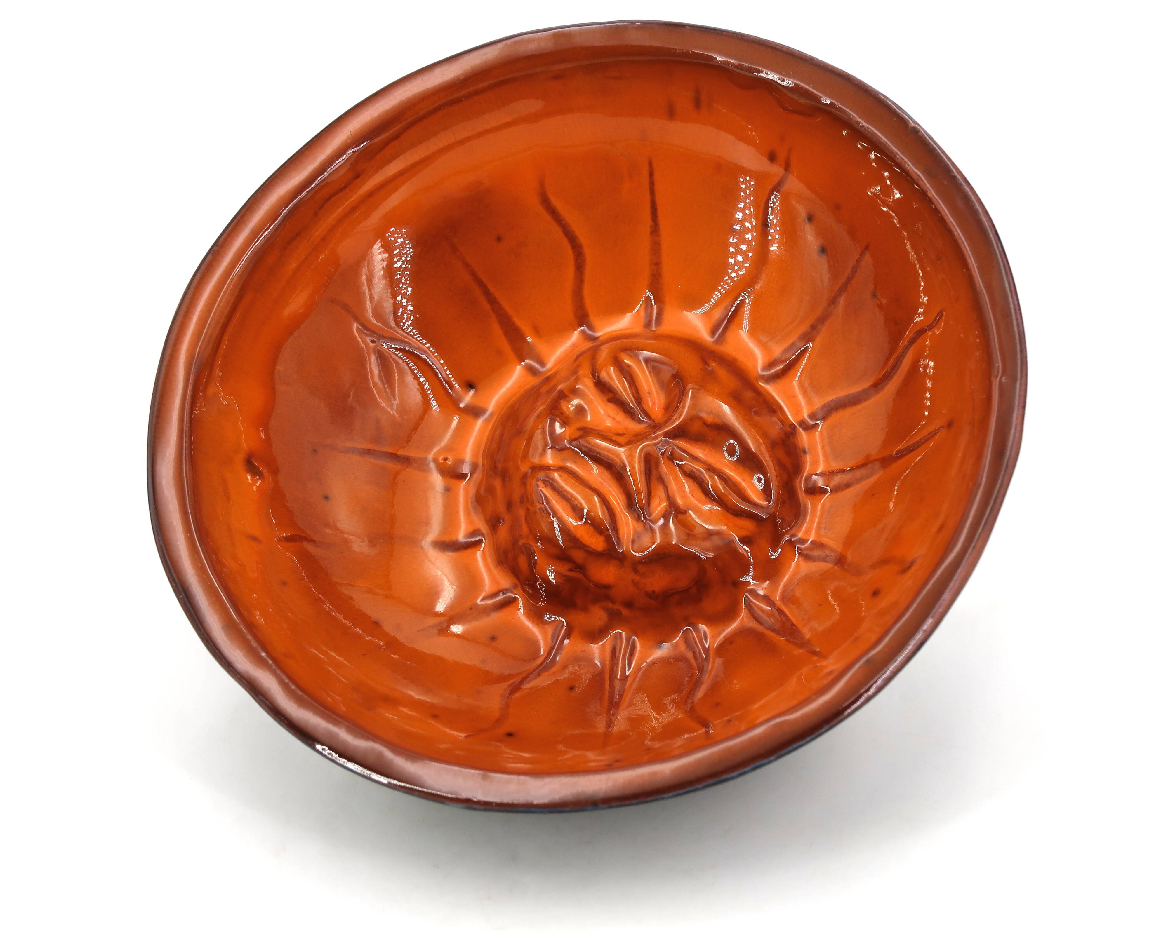 Mexican ceramic catchall in orange and black, 1970s sun face.