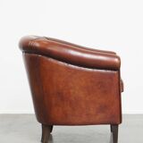 Sheepskin club armchair in a warm deep colour finished with black piping