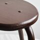 Dark brown metal stool, minimalist three-legged design