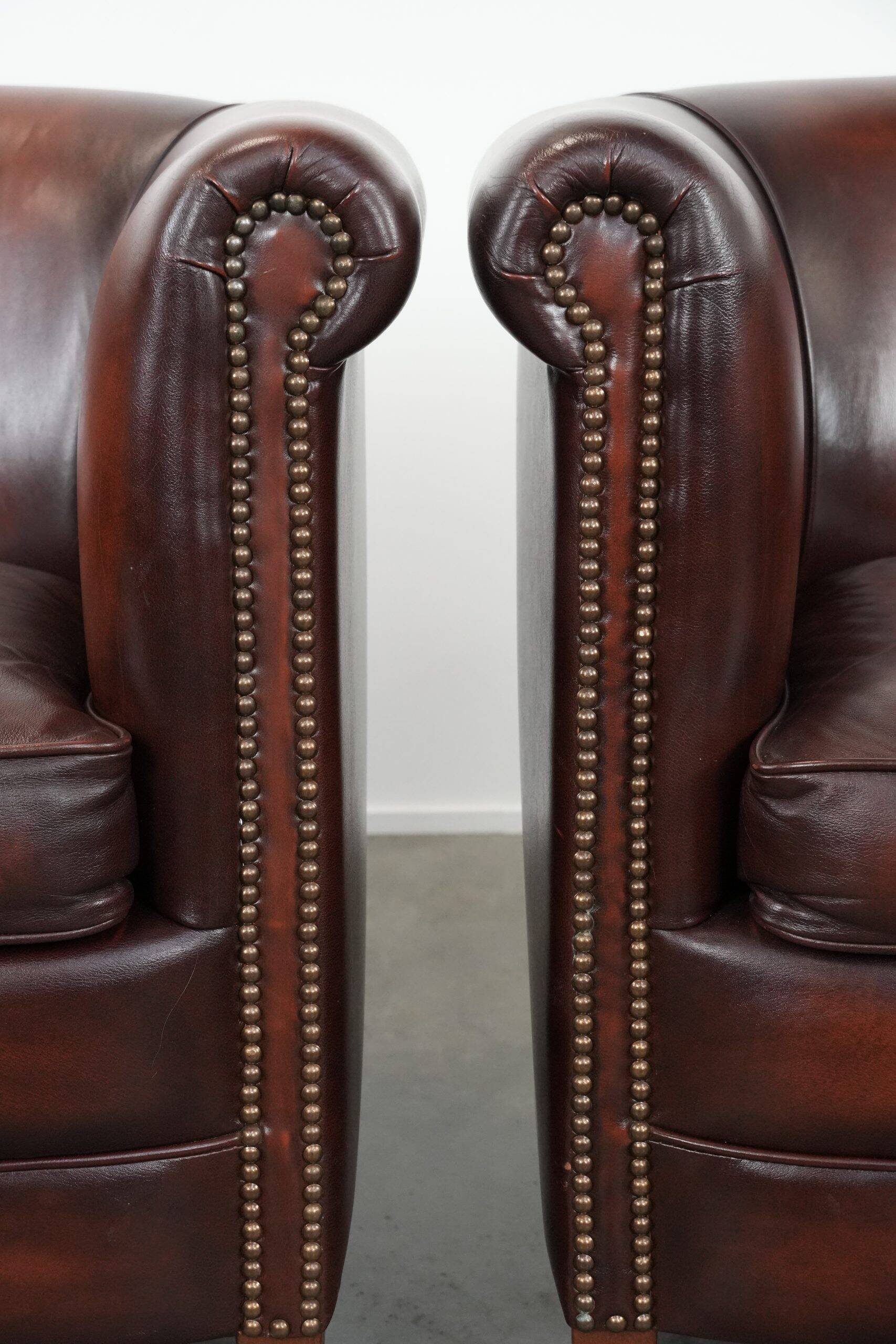 Set of two cow leather club armchairs in a luxurious red/brown colour