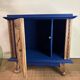 Small vintage upcycled side table in midnight blue and raw wood, with a rose-shaped door.